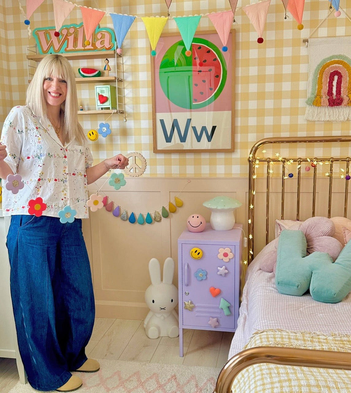 Coral Atkinson standing in her child's bedroom with handmade decor and colorful decorations.